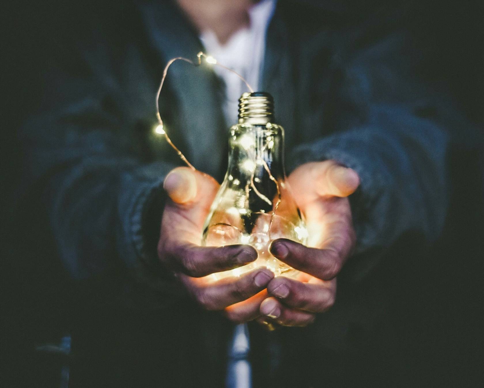 Incandescent light bulb emitting warm light in a bottle like a lantern with a perfume fragrance.